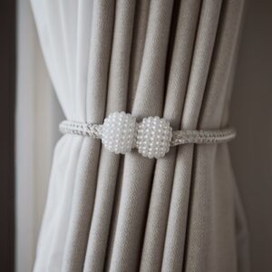 Luxurious gray curtains held by a decorative pearl tieback, adding elegance to any room.